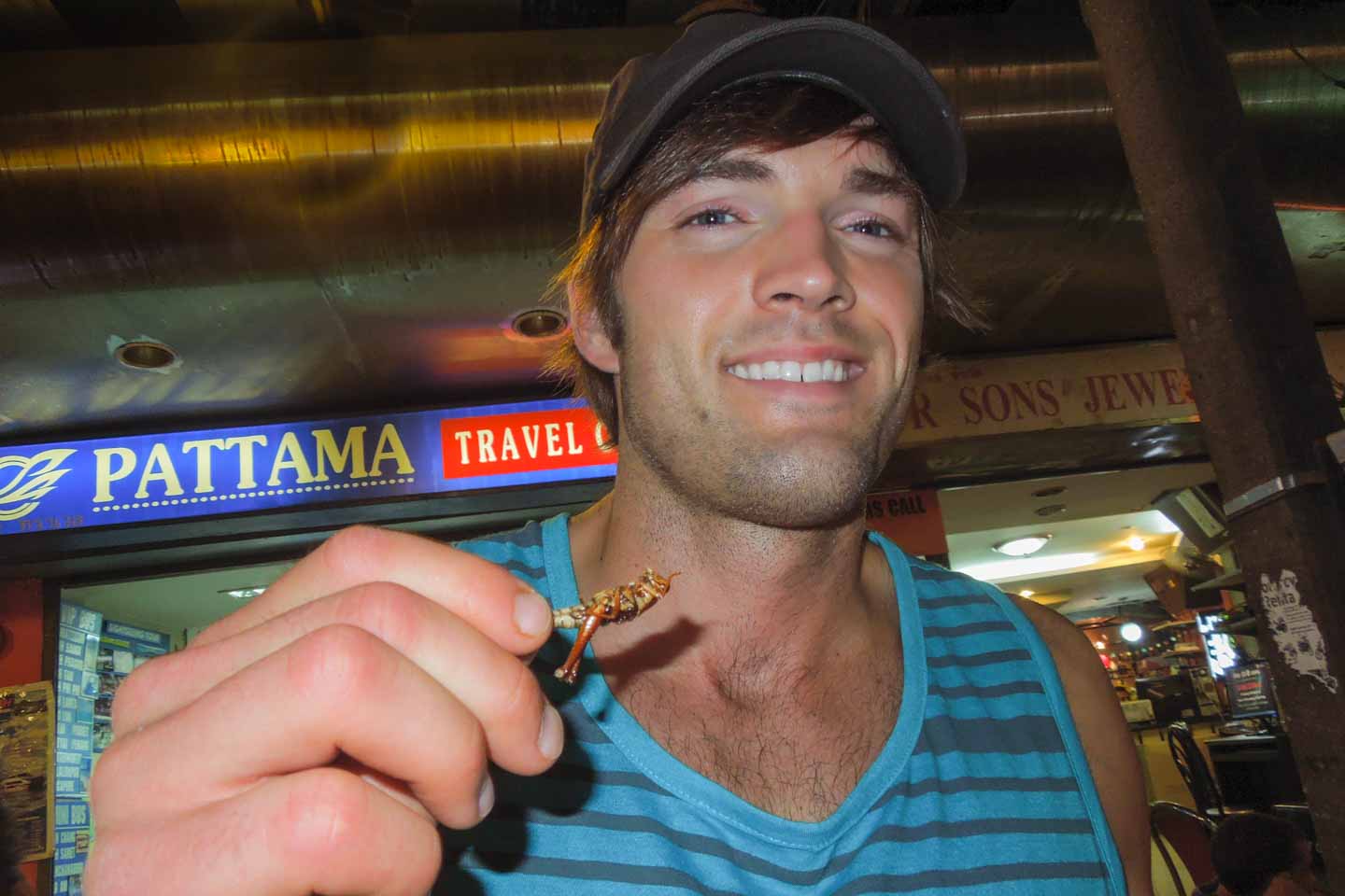 man holding a locust- eating bugs in Thailand