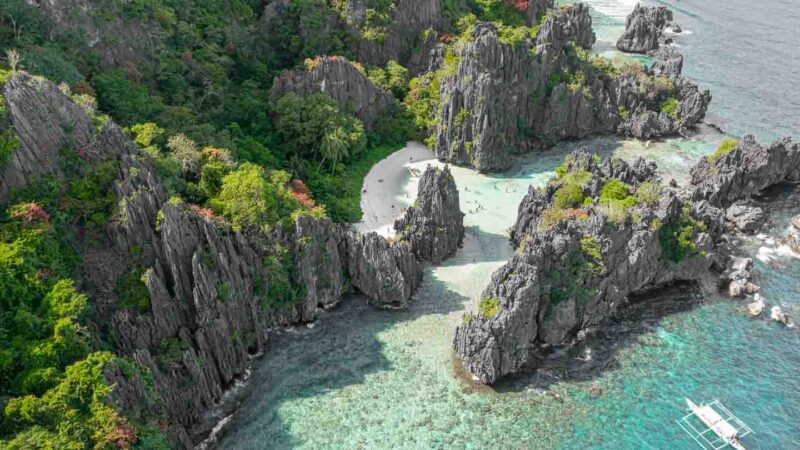 Hidden Beach drone photo with large rocks surrounding a secluded beach in el Nido Palawan