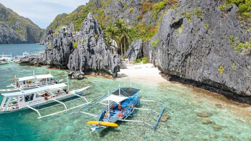 Blue boat anchored in tropical waters infront of the Matinloc Shine