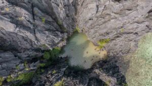 Drone photo of Secret Lagoon with tall limestone rock walls surrounding a small lagoon - El Nido Day Trip A
