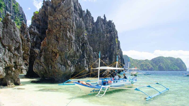 White Filipino boat anchored at Secret Lagoon Beach