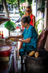 Vietnamese lady making Bahn me sandwich in Hoi An Vietnam