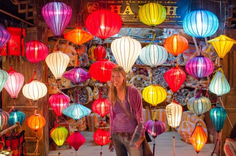 A woman standing in front of a shop selling lanterns for the Hoi An Lantern festival