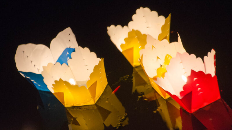 A group of colorful lanterns float down the river in Hoi An during the full moon lantern festival
