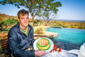 Birthday boy and cake by the pool at Stanley Safari Lodge Livingstone Zambia