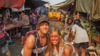 couple at the train market in Bangkok with train coming