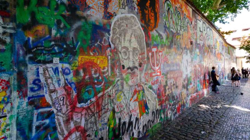 View of the Lennon Wall in Prague covered in graffiti about John Lennon and Beatles Lyrics - Things to see in Prague