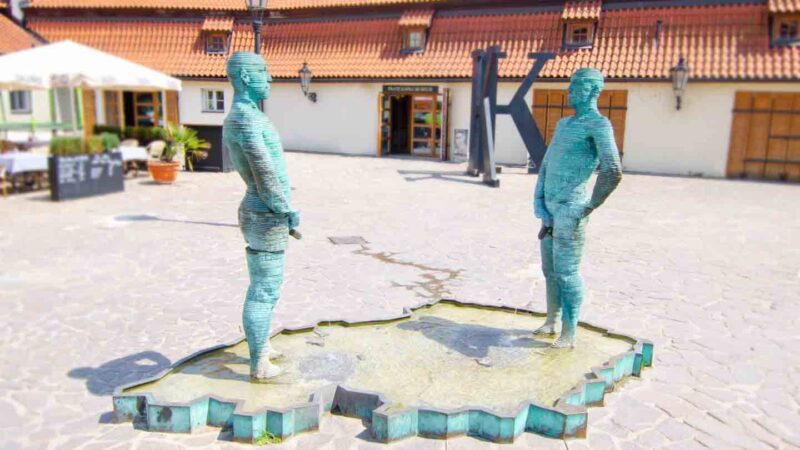 Statues of two men urinating on a map of the Czech Republic Titled "Piss" by David Cerny as Czech sculptor
