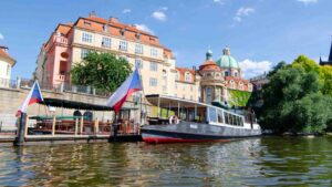 River Boat in the Vltava river in Prague with a Czech flag - Best things to do in Prague