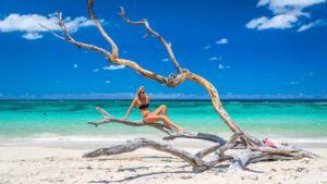 Woman on Driftwood on the beach Playa Jibacoa Cuba