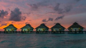 sunset behind the over water bungalows at Ellaidhoo Maldives by Cinnamon