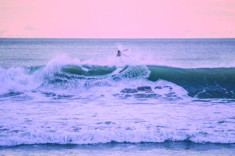 Surfer surfing in Kuta Beach Bali