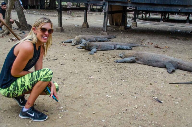 Girl at Komodo National Park on Rinca Island with Komodo Dragons behind