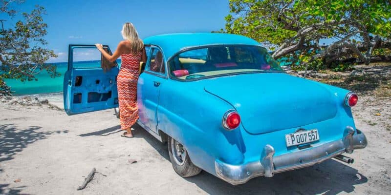 girl on Playa Jibacao Cuba in a blue old classic car in Cuba - Things to do in Cuba