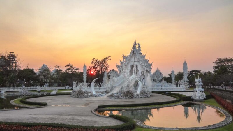 Sunset over the white temple in Chiang Rai Thailand is a great destination for honeymooners