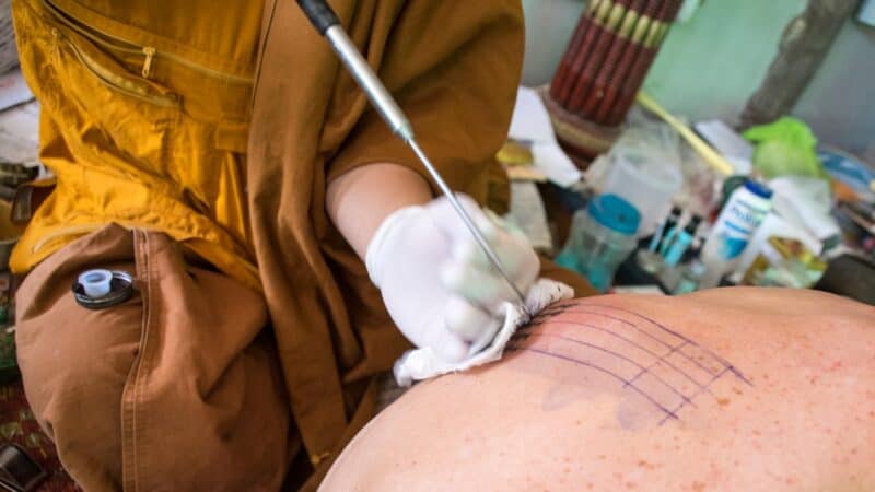 Close up of sak yant tattoo work during the traditional process