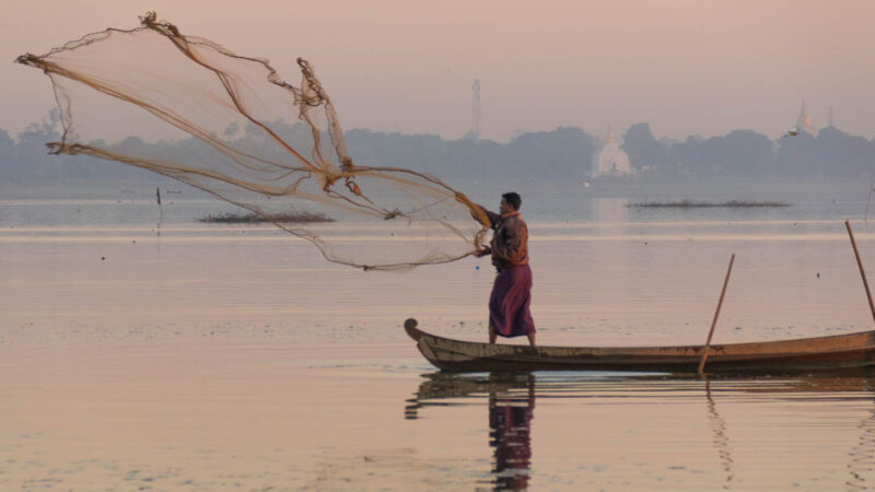 Local Fisherman throws his net near the U Bein Bridge in Mandalay Myanmar - Things to do