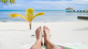 Womans feet infront of the best beach in Ambergris Caye in Belize