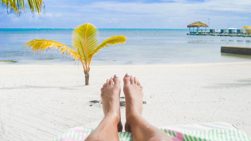 Woman's feet infront of the best beach in Ambergris Caye in Belize