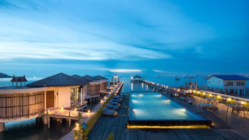 night time photo of pool and over water villas at Kept Bangsaray Hotel in Pattaya Thailand