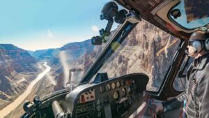 A pilot flying a helicopter inside the grand canyon on a tour