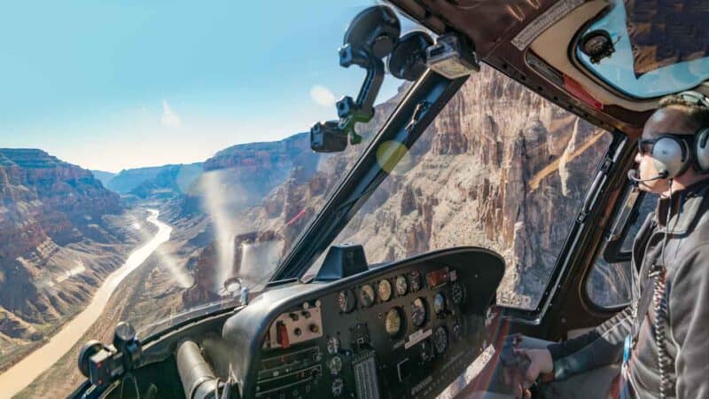 Top 10 Grand Canyon Helicopter Tours 2024- Best & Cheapest 1 A pilot flying a helicopter inside the grand canyon on a tour