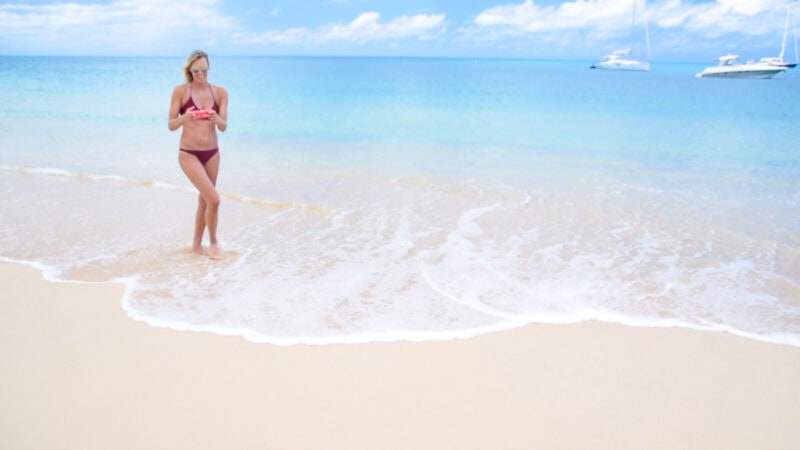 Woman on the beach in Anguilla getting Rental car directions for offline use