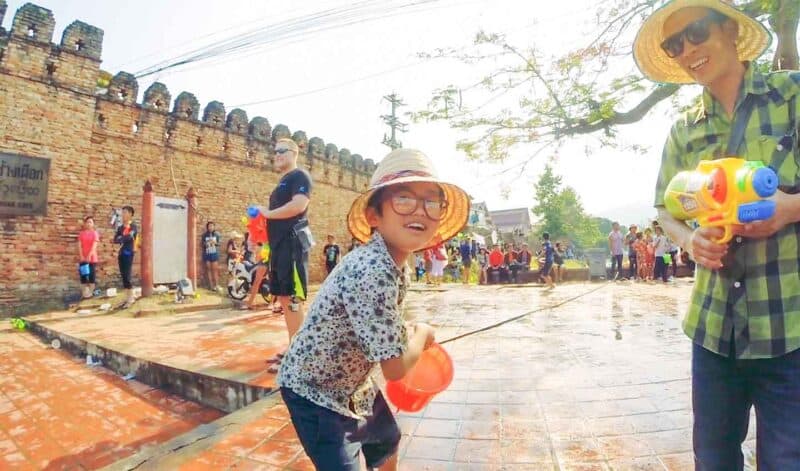 Young boy about to throw a bucket of water during Songkran