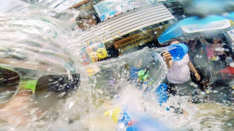 Man getting hit by a bucket full of water during Songkran