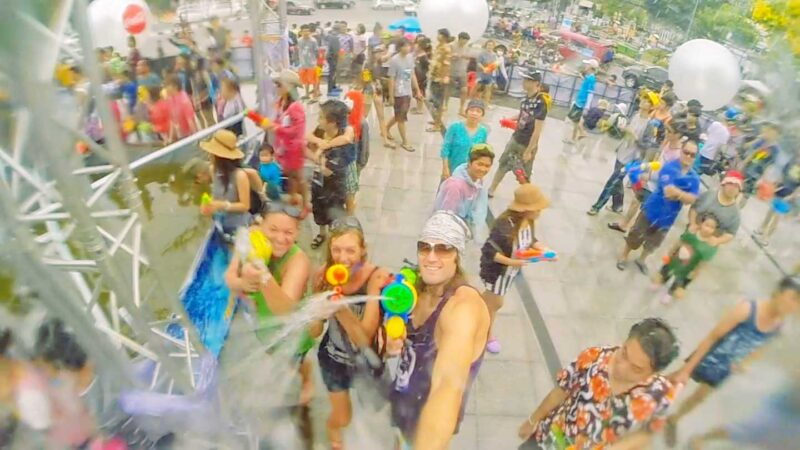 three tourists squirt the camera at the Songkran festival