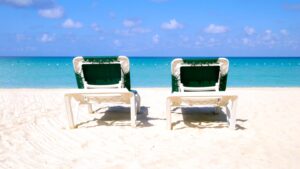 Two beach chairs sit empty waiting for people on 7 mile beach in Negril Jamaica
