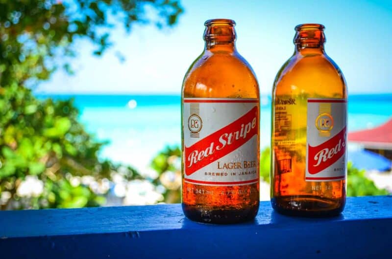 Red stripe bottles sitting on the rail over looking the beach in Negril Jamaica