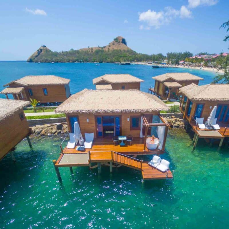 women in tub of outdoor bathroom in overwater bungalow at Sandals St. Lucia Grande resort