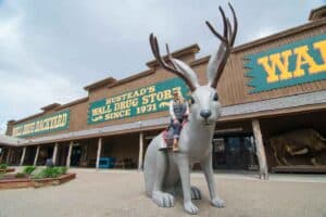 Woman ride large jackalope in the backyard of Wall Drug in Wall South Dakota - A must on any road trip