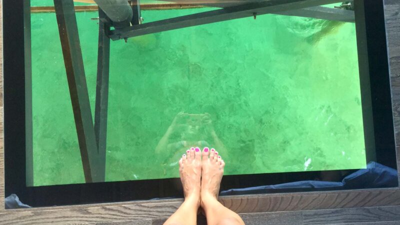feet on the glass floor in the overwater bungalows in St. Lucia at Sandals Resort