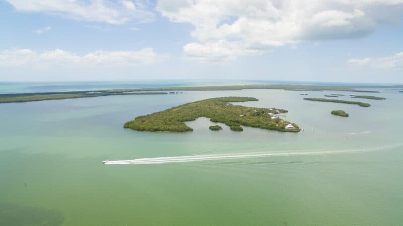 Drone photo of Cabbage Key with a boat driving by - Things to do in Fort Myers Florida