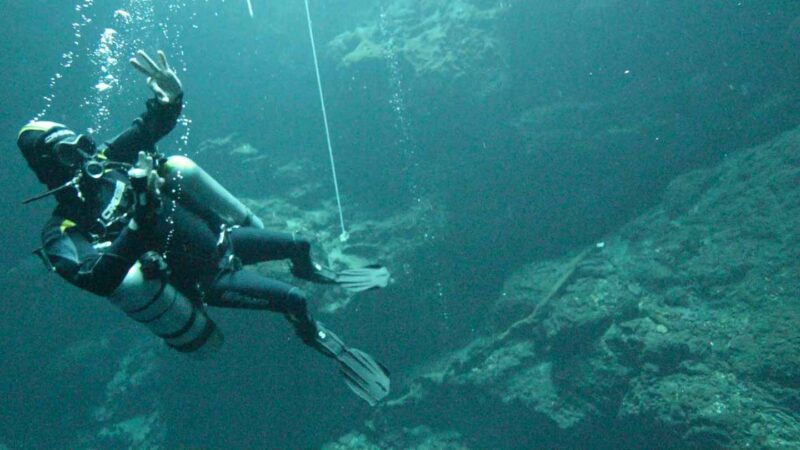 Diver giving signals in El Pit Cenote