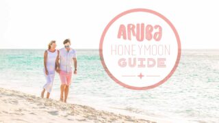 Couple walking the beach in Aruba on a honeymoon -featured image