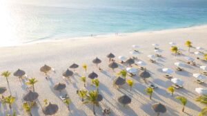 Aruba honeymoon destinations - Manchebo Beach just before sunset with beach umbrelas