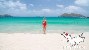 Woman in a red swimsuit stands on Flamands Beach one of the best beaches in St. Barts