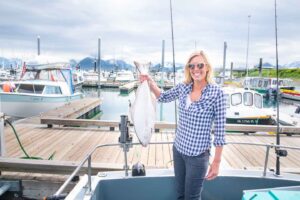 Woman holding a halibut caught while fishing in Homer - Things to do in homer Alaska