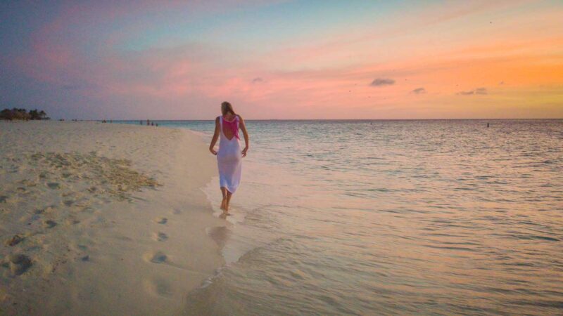 Woman walking on the beach at sunset in Aruba Honeymoon in Aruba