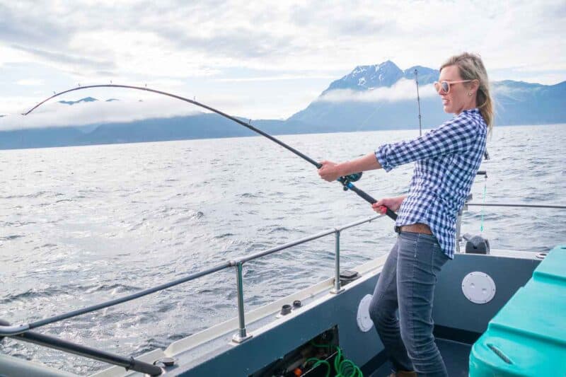 girl halibut fishing with a fish on the line