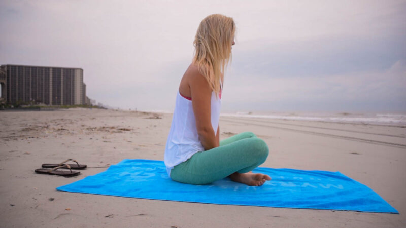 woman doing early morning yoga on Myrtle Beach on a weekend getaway