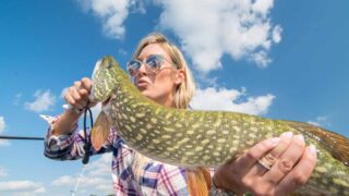 Girl kissing a northern fish in Green Lake Wisconsin