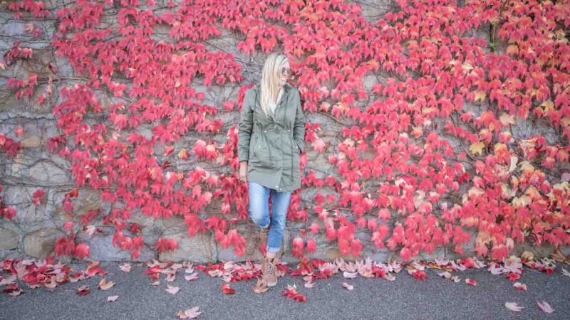 Woman with Merrell Boots from Zappos in front of a wall covered in red leaves