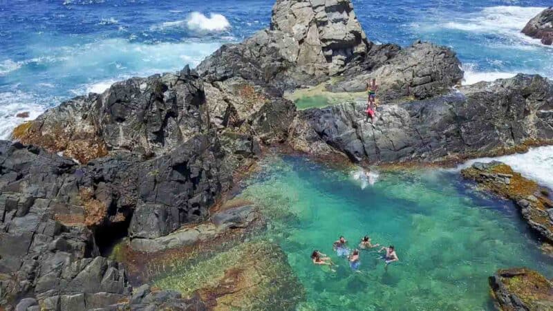 Man cliff jumping at the Aruba Natural Pool