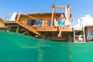 Woman sitting on the Balcony of an Overwater bungalow taken using a GoPro Dome over under photo