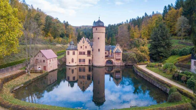 drone photo of Mespelbrunn Castle with pond reflection, one of the best kept secret castles in Germany