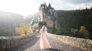 Woman in a dress in front of Burg Eltz Castle in Germany
